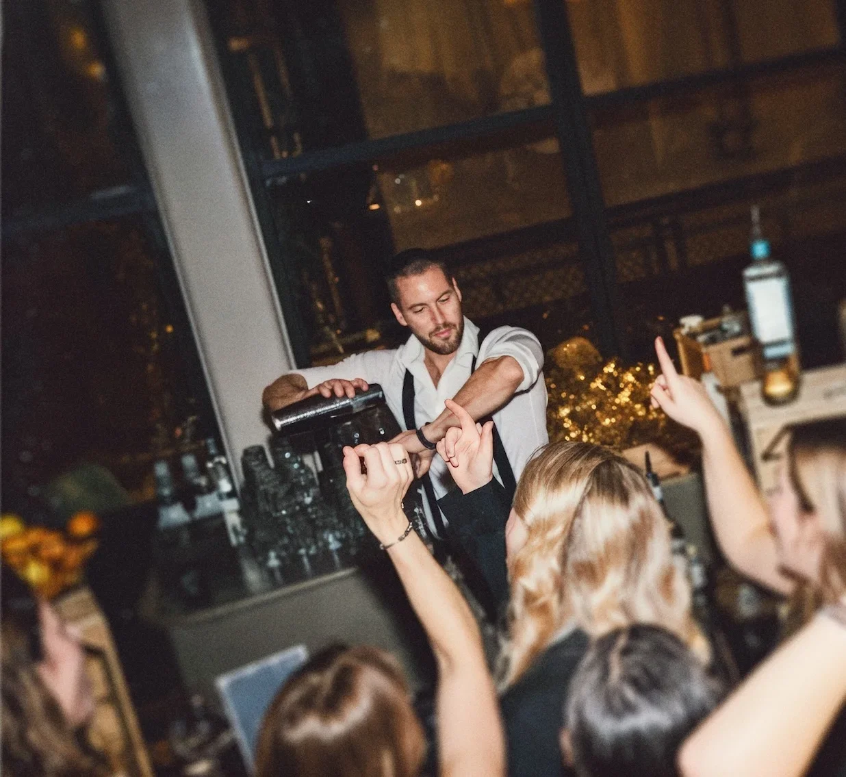 Bartender van Cocktail Moves shakt een cocktail tussen juichende gasten op een feest